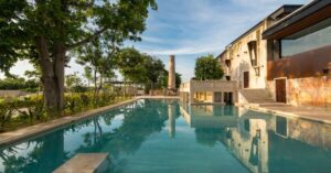 Restored 19th-century henequén hacienda Casa Club at Hacienda Kikteil near Mérida, showcasing award-winning interior design, garden views, and community gathering spaces within the residential development.