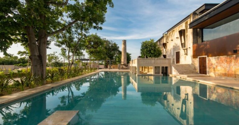 Restored 19th-century henequén hacienda Casa Club at Hacienda Kikteil near Mérida, showcasing award-winning interior design, garden views, and community gathering spaces within the residential development.