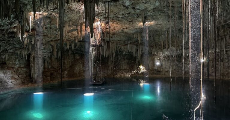 Crystal-clear cenote near Mérida with sunlight streaming into turquoise water and swimmers enjoying the natural cave
